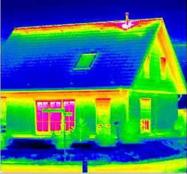 Thermal image of the exterior of a home with cold blue ground and roof, with warmer yellow-green sidewalk, walls, skylight, and peak of roof where the heat loss from the home has risen.